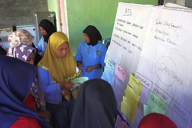 Mitglieder der Migrantinnengruppe „Pada Patuh“ in Ketapan Raya Village führen eine Diskussion mit Kindern von Migrant*innen durch, um Probleme zu identifizieren und adressieren. (Foto: AWO International)