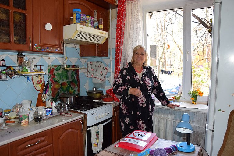 eine Frau steht in die Küche vor ihrem reparierten Fenster 