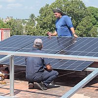 Zwei Männer installieren Solarpanele