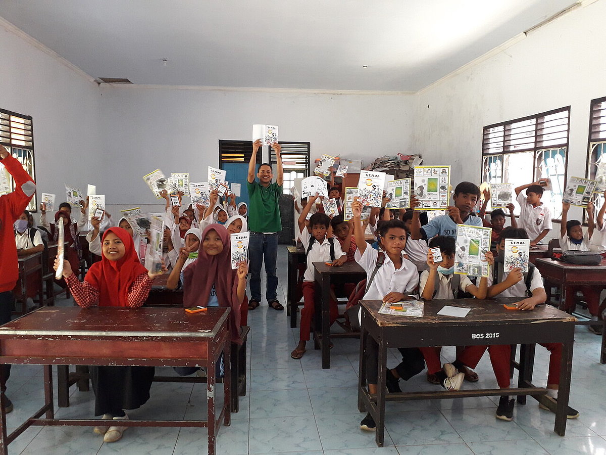 Kinder einer Schulklasse posieren mit Comics