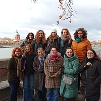 A group of women are standing together and looking at the camera.