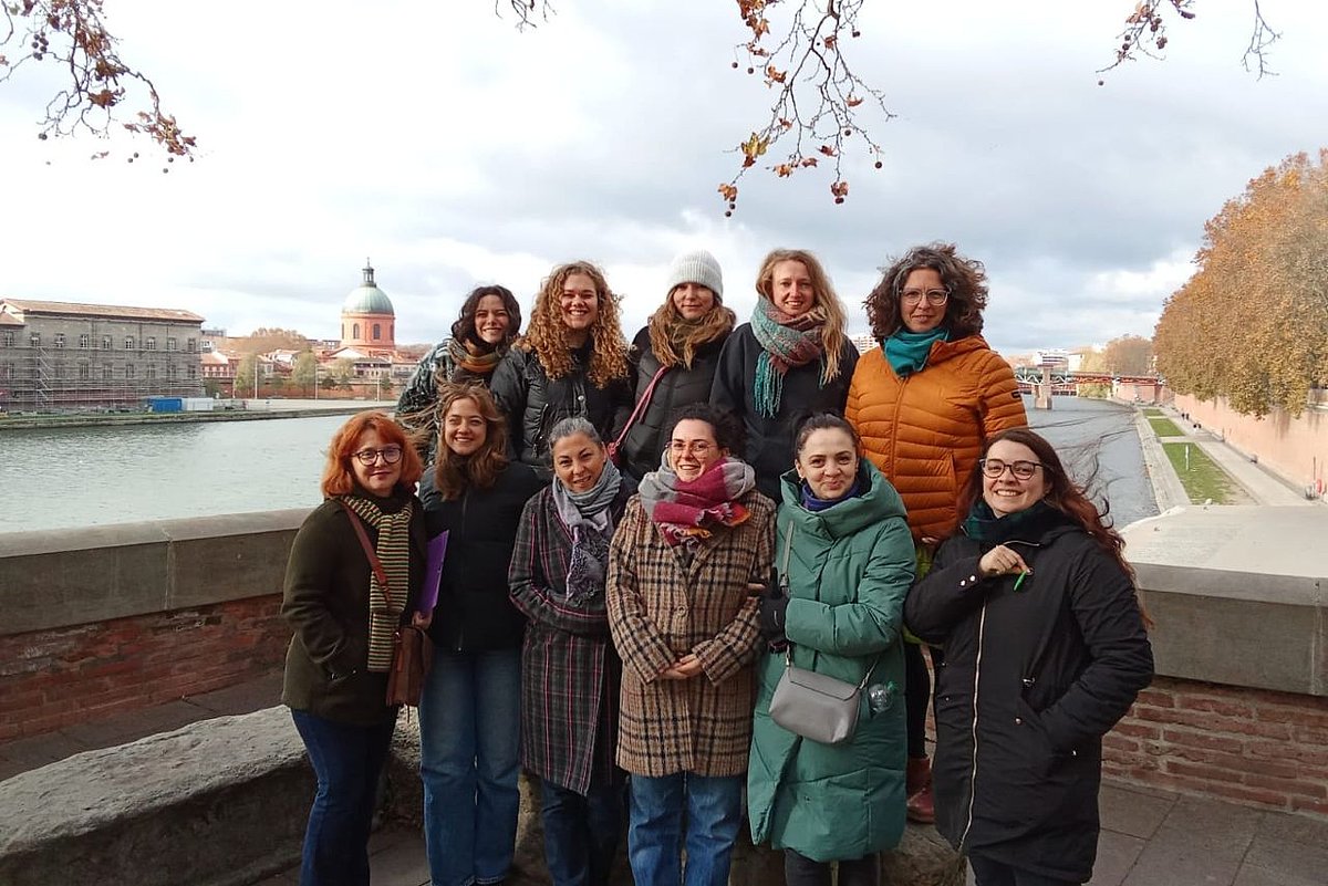 A group of women are standing together and looking at the camera.