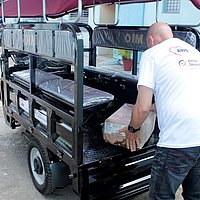 Ein Mitarbeiter des CCRD-Cuba belädt ein Lastenrad mit einem Paket.