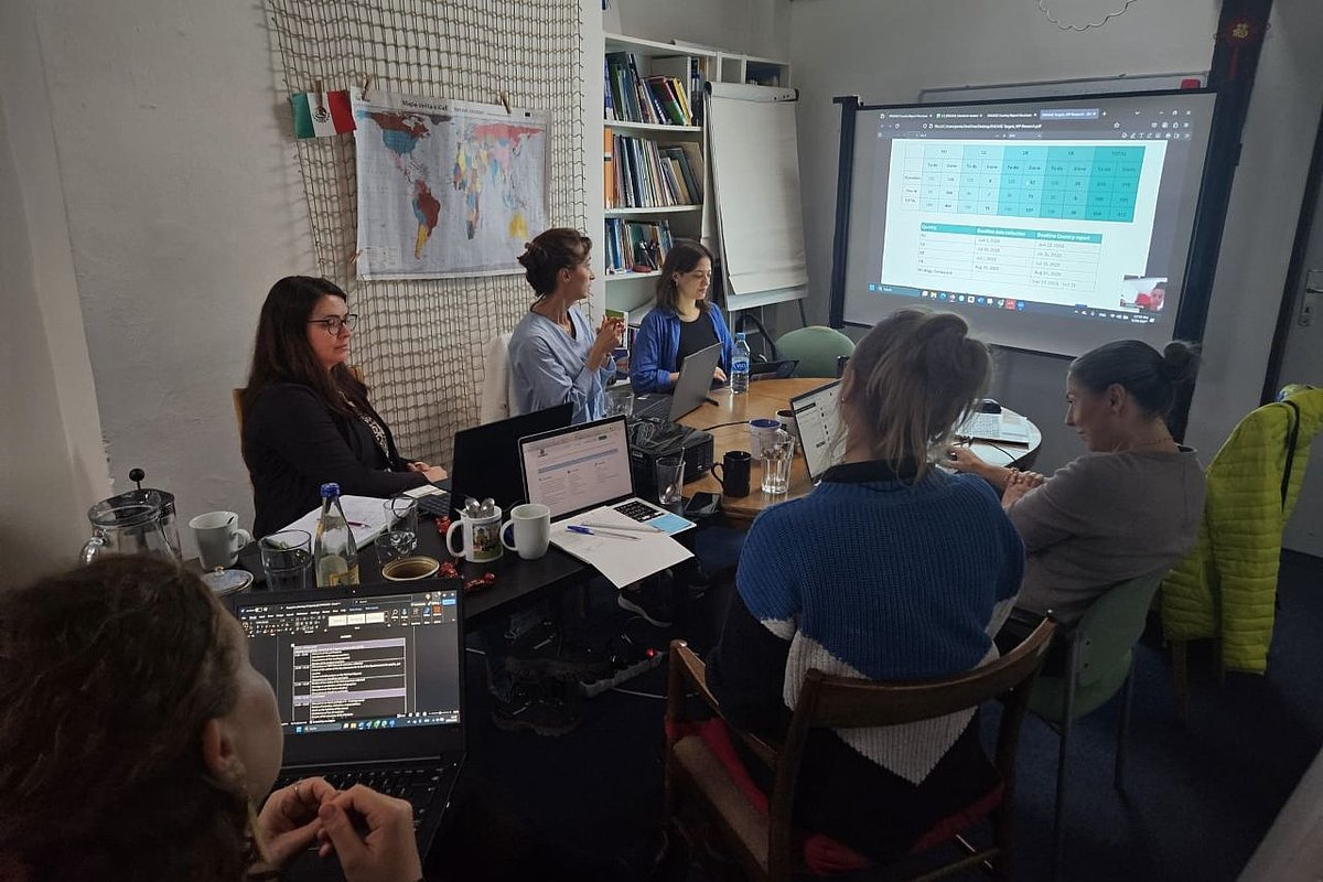 A group of people are sitting at a table in a seminar room.