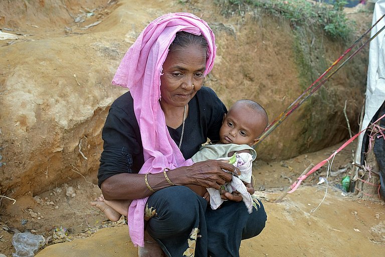 Titelbild der aktuellen weitblick-Ausgabe: Eine Frau mit Kind in einem Flüchtlingscamp in Bangladesch. Wie Hunderttausende Rohingya musste sie fliehen. Die Rohingya leben zwar seit Generationen in Myanmar, werden aber massiv diskriminiert. (Foto: AWO Int