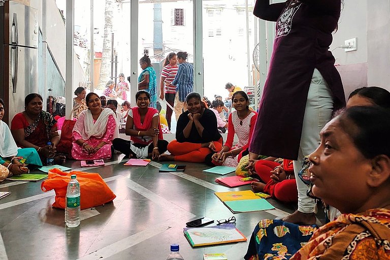 Frauen aus Indien sitzen auf dem Boden
