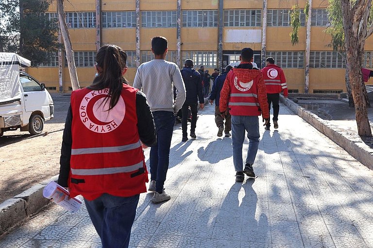 Menschen mit dem Rücken zu sehen. Sie Tragen Westen von der Partnerorganisation Heyva Sor a Kurd