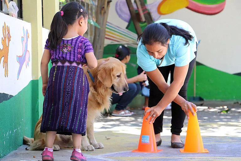The picture shows a woman, a girl and a dog taking part in a disaster preparedness course.